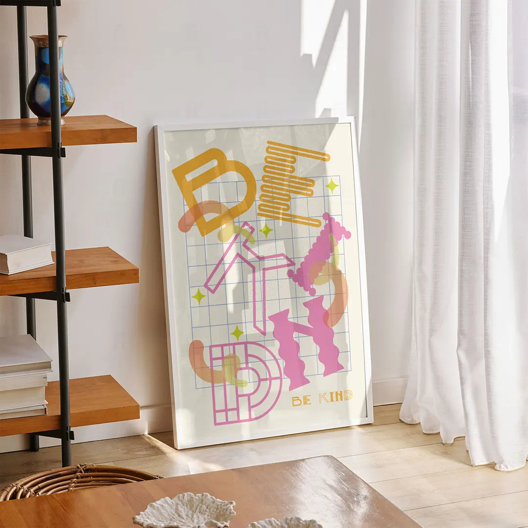 Plakat z kolorową grafiką i typografią z napisem "Be Kind" w salonie