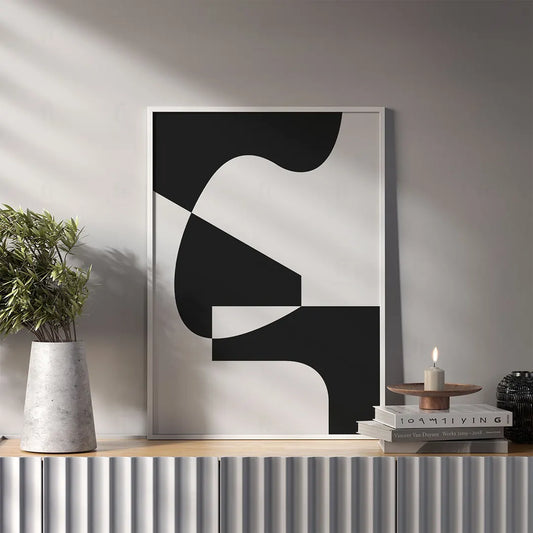 Plakat z czarno-białą, abstrakcyjną grafiką przedstawiającą zbalansowaną kompozycję geometrycznych form wiszący w salonie